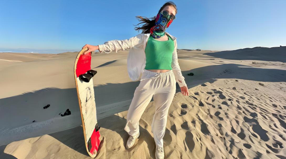 Sandboarding down golden dunes in Peru